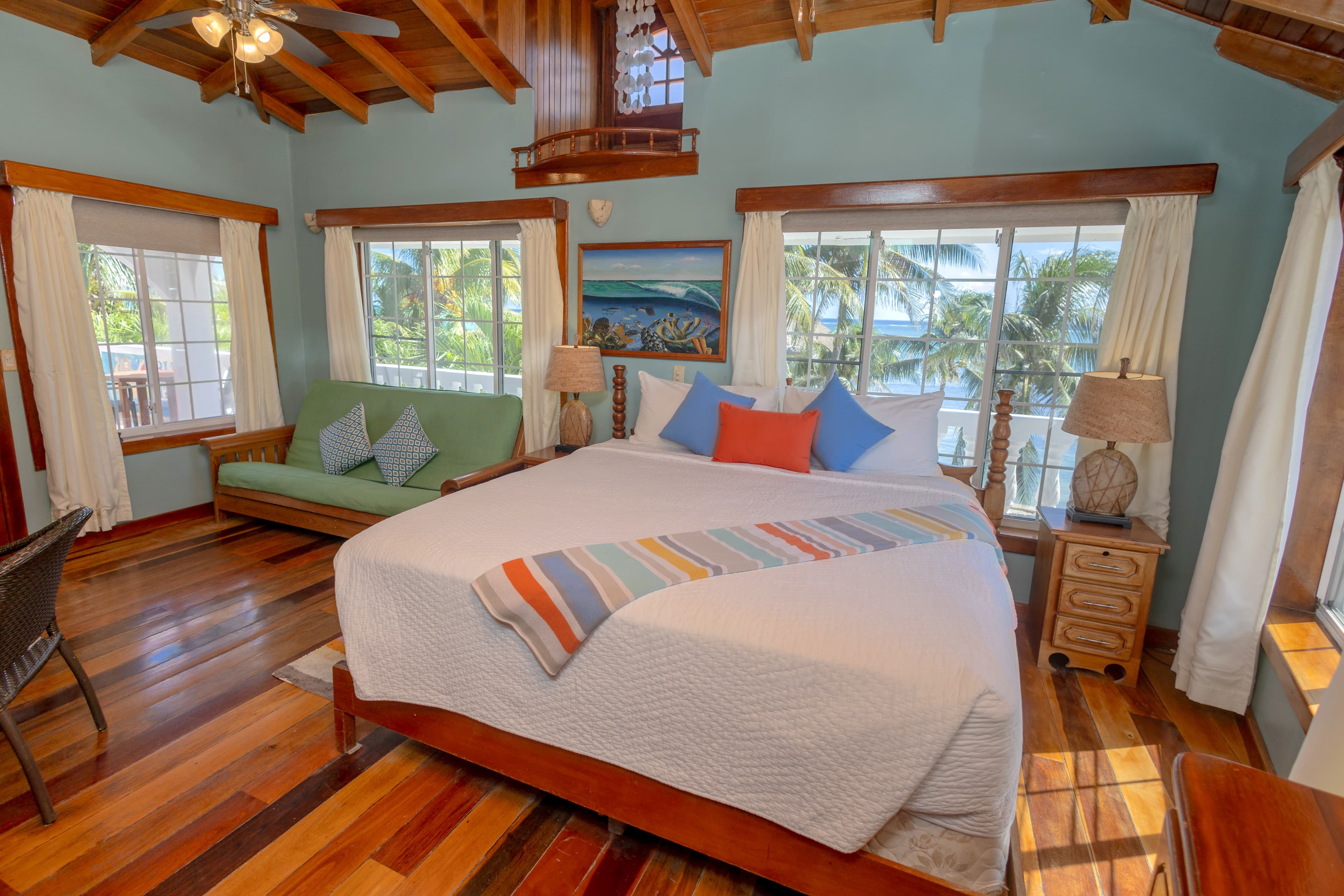Large window over the bed ocean view, palm trees and the pool