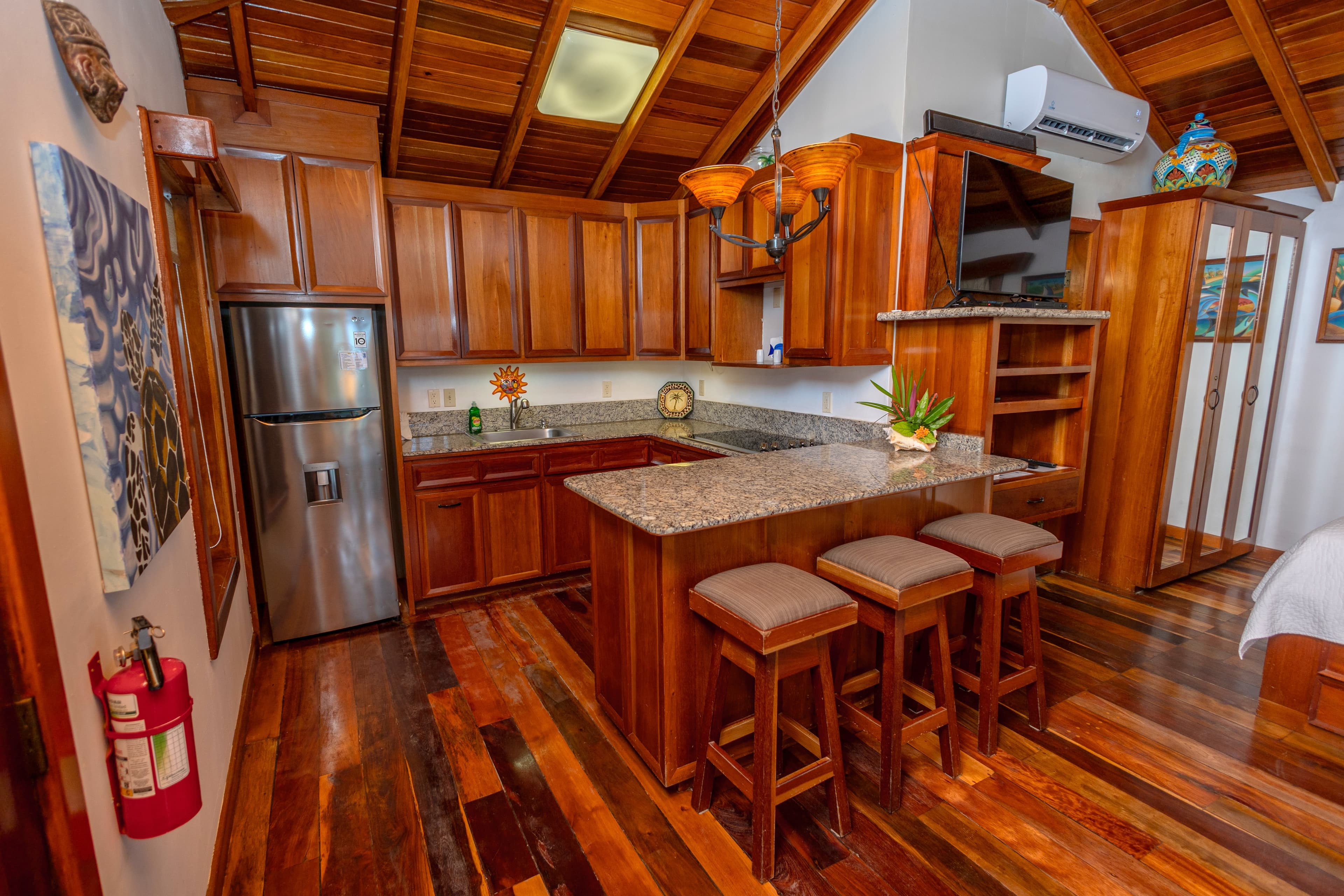 Kitchen and dining table with refrigerator, stove and oven, microwave, sink, coffee maker, blender, pitcher of filtered water and all serving items.