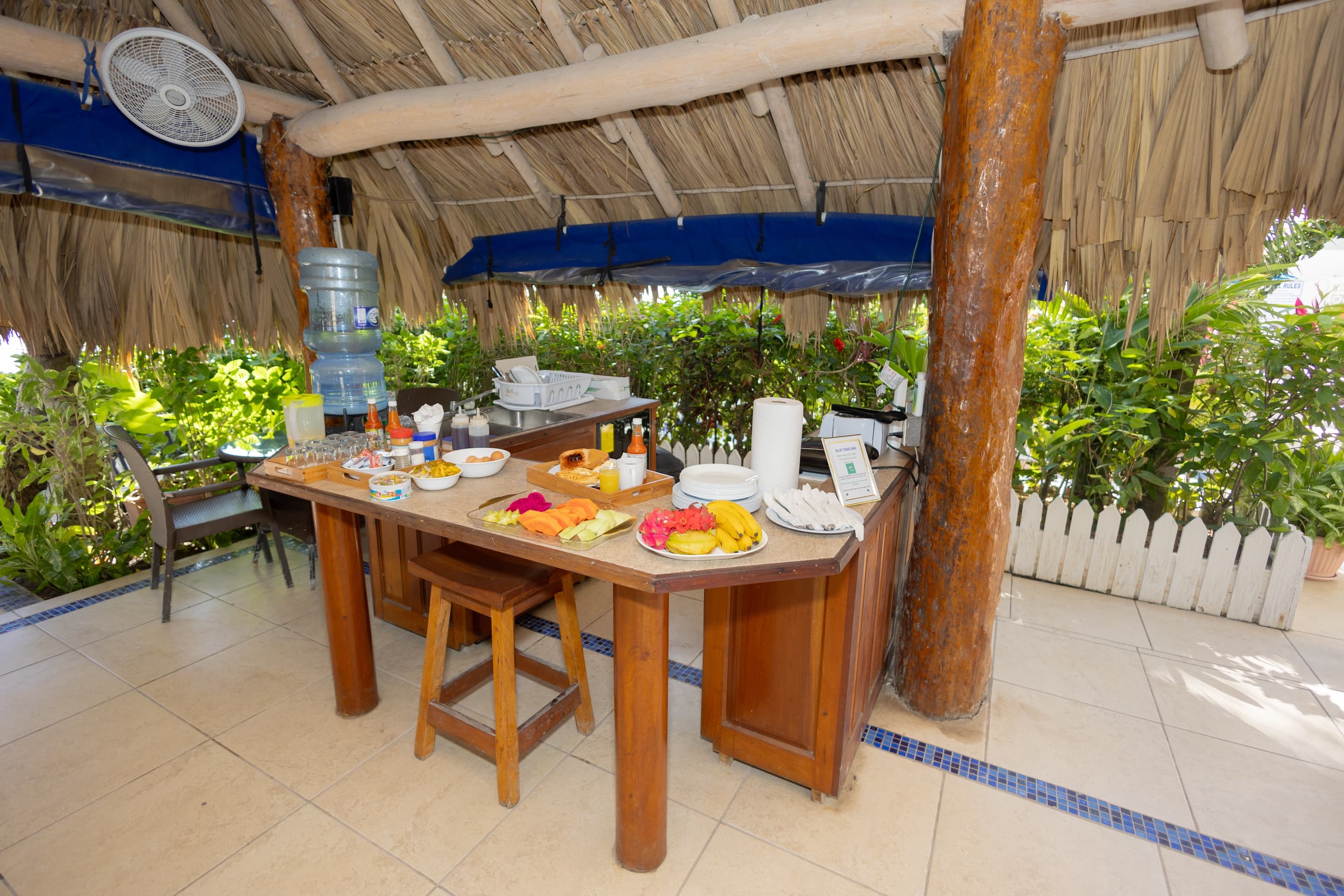 Welcome to Suite #5 at Blue Tang Inn as you enter the dining area with green futon, full kitchen, king bed, large windows with views of the beach and ocean