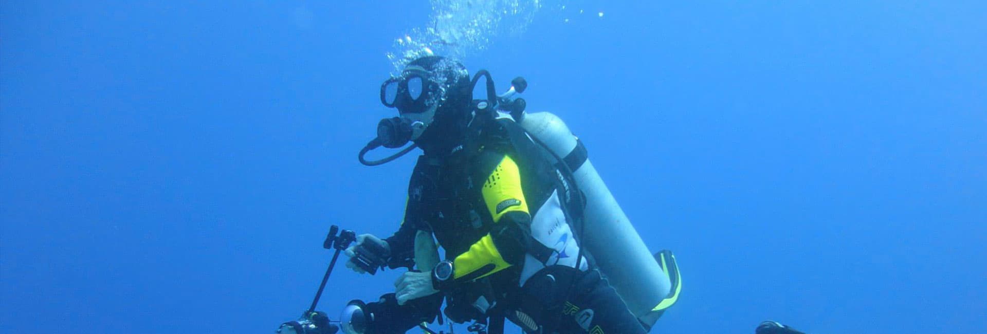 A diver immersed in deep blue water, equipped with scuba gear.