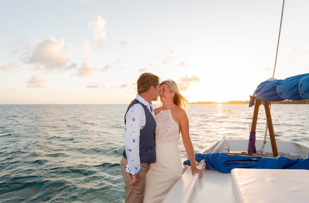 A couple shares a romantic moment on a boat at sunset.