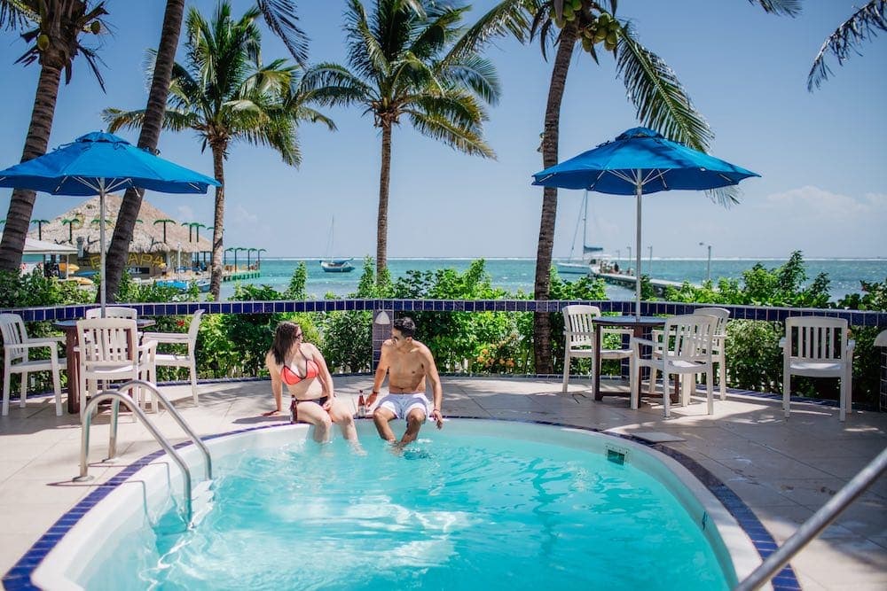 A couple enjoying an afternoon by the pool at our Belize Resort, after enjoying an exciting day snorkeling on the Belize Reef