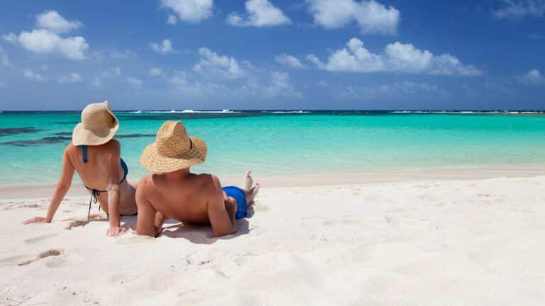 couple sunbathing on beach in the caribbean